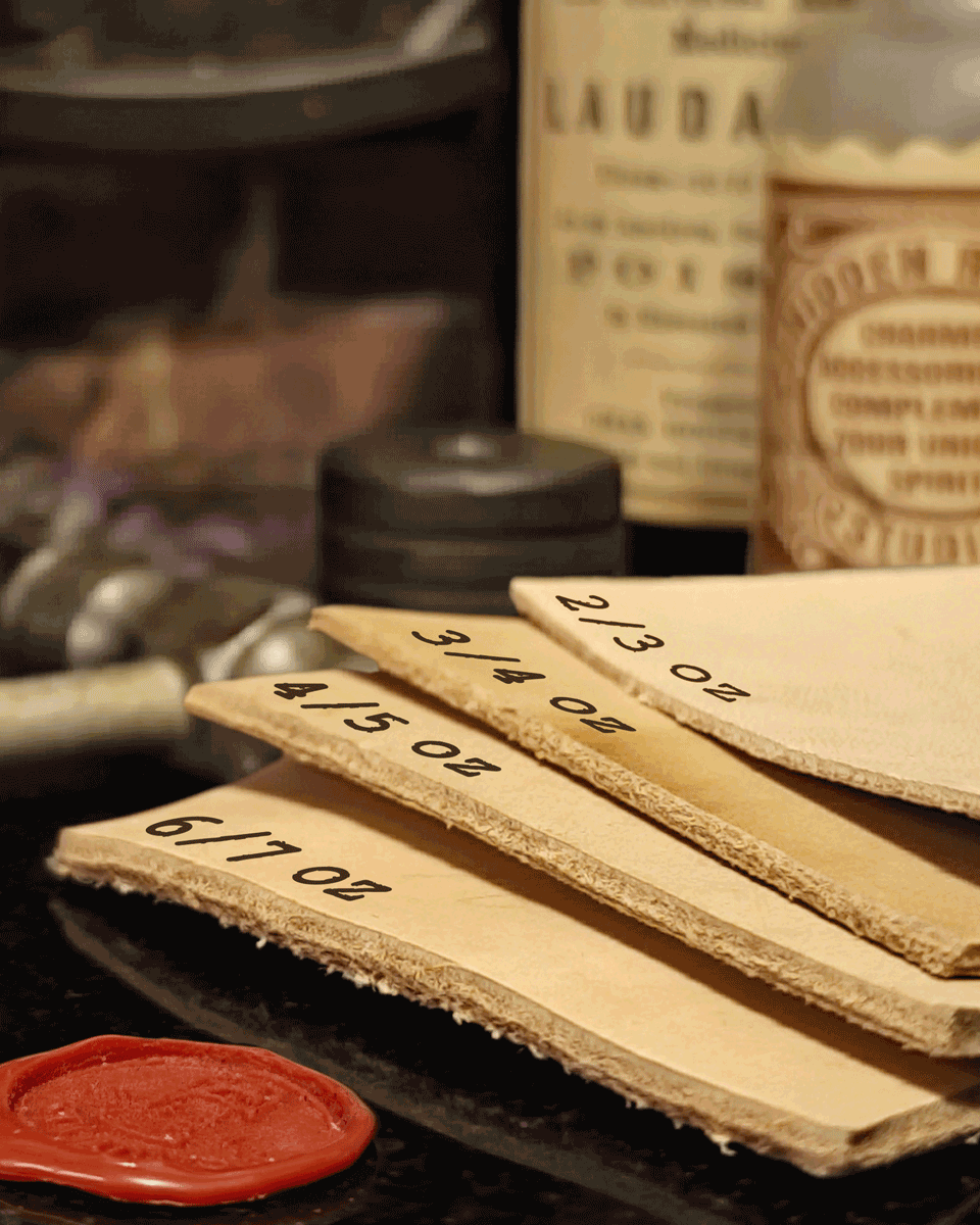 A stack of leather with thickness measurement labels and a red wax seal on a dark surface.
