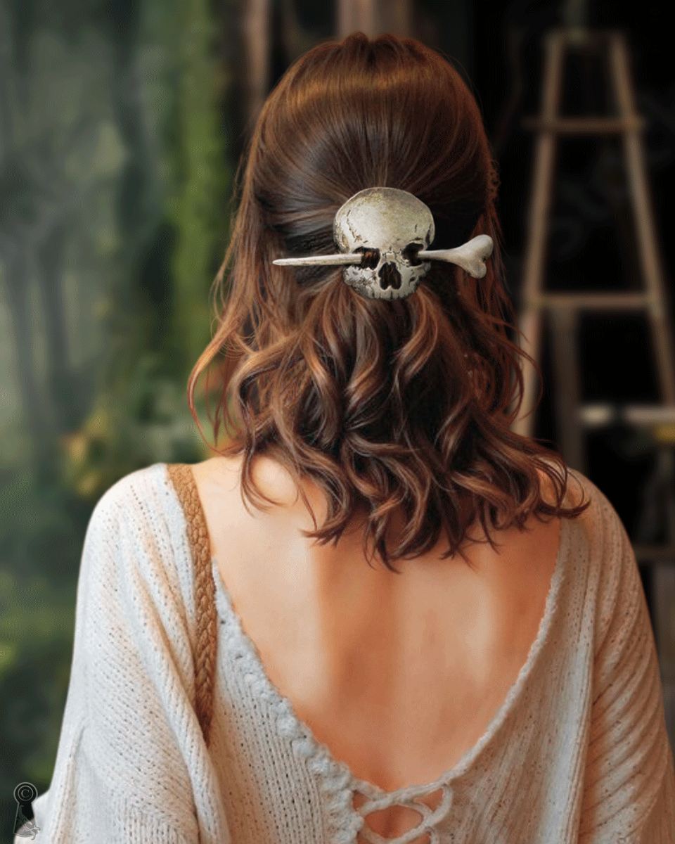 Person with leather skull and a wood, resin bone hair accessory in a wavy hairstyle, wearing a beige cardigan.