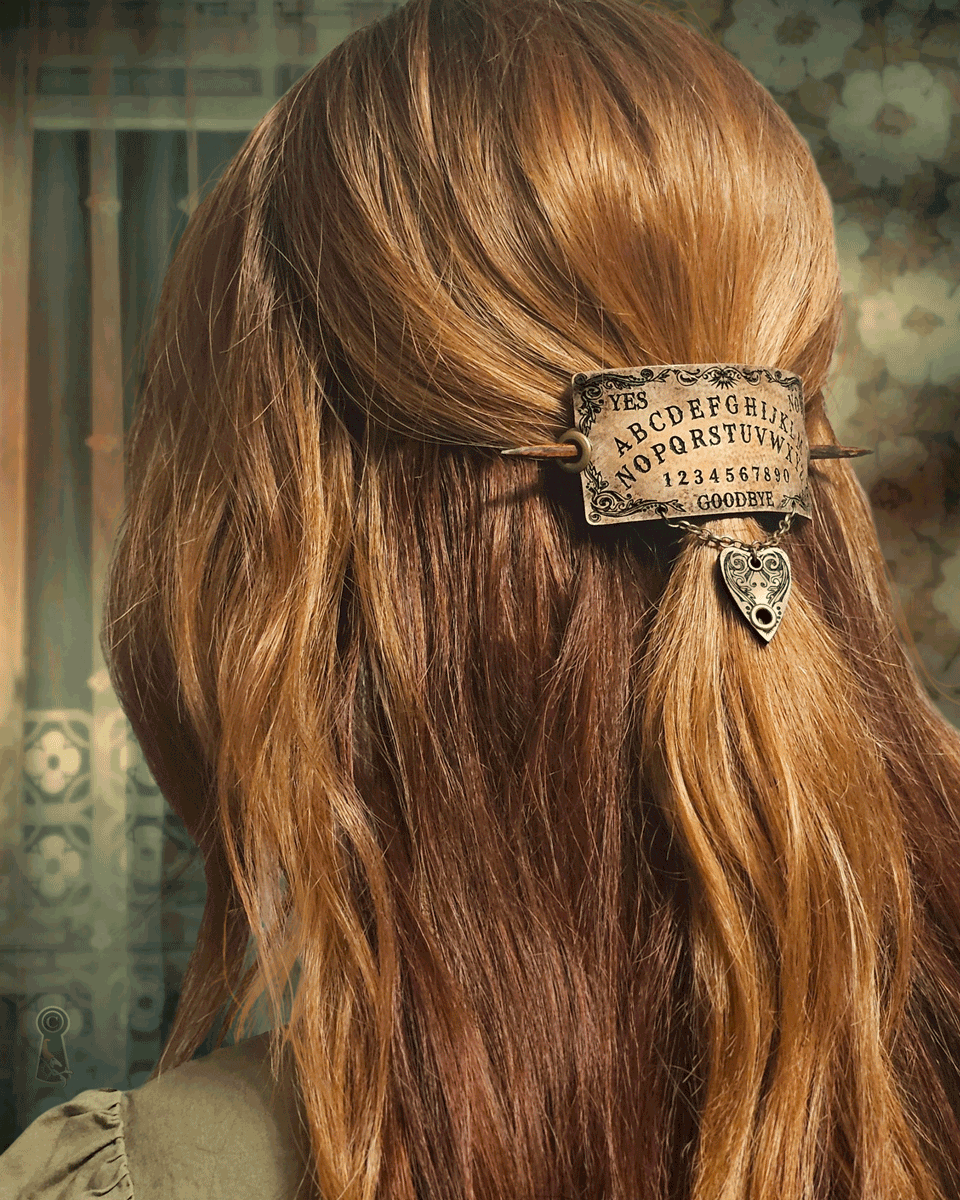 Close-up of a person with long red hair wearing a decorative spirit board hair accessory.