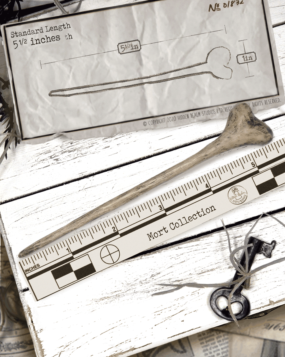 Ruler with measurements on a wooden surface next to the bone shaped hairstick.