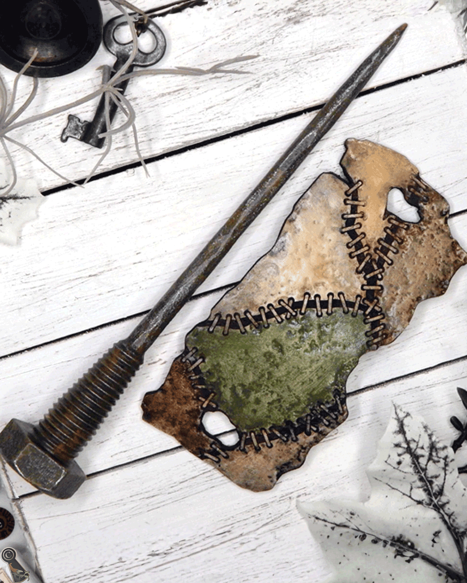 Long metal bolt with a hair slide of stitched patches of colors separated on a white wooden surface.