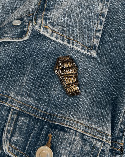 Coffin-shaped pin on a denim jacket