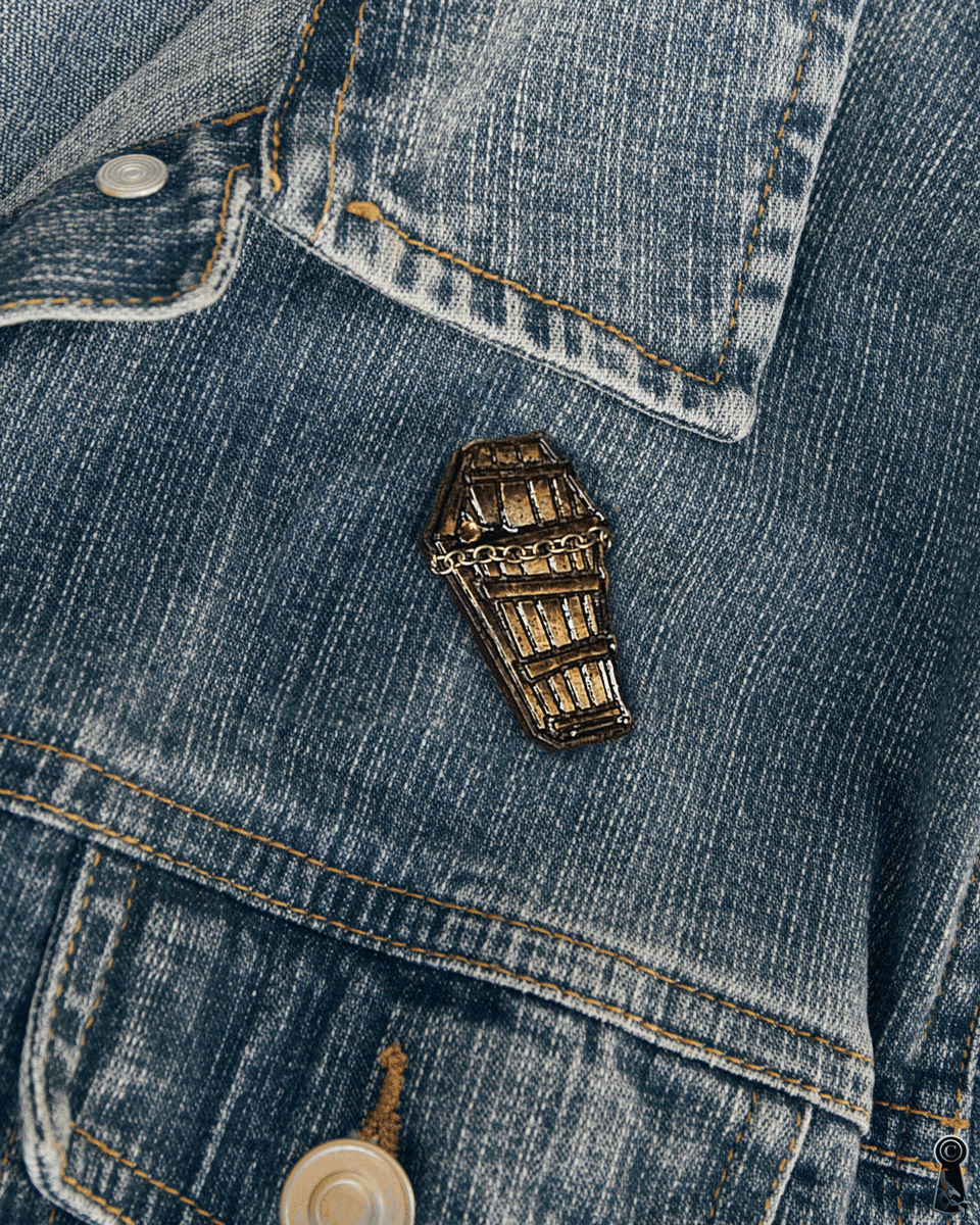 Coffin-shaped pin on a denim jacket