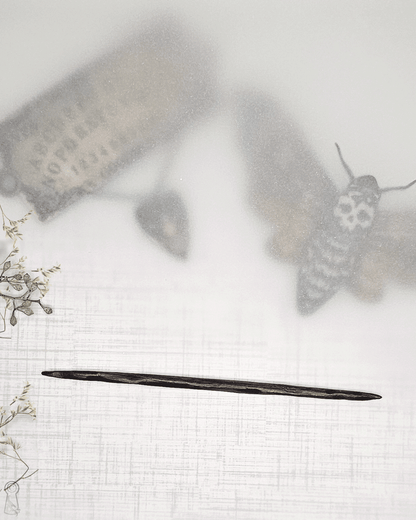 Decorative hairpins of a moth, a spirit board and a wood stick with floral decorative elements on a textured white background