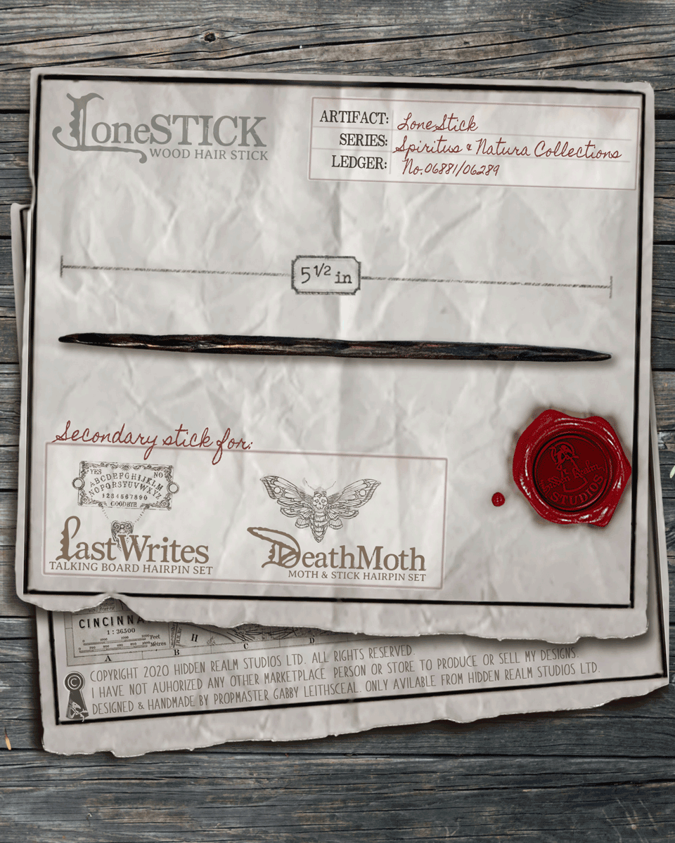 Wooden hair stick with branding and measurements on a textured paper background