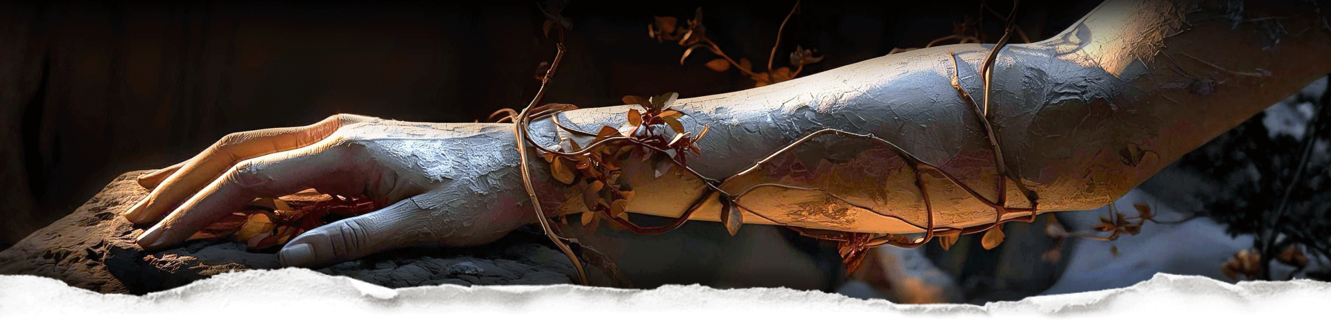 A plaster arm and hand with dried leaves and flowers wrapped around the wrist on a textured surface behind torn paper